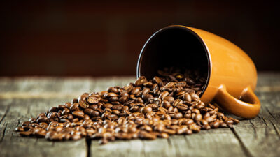 Coffee beans and coffee mug on wooden table