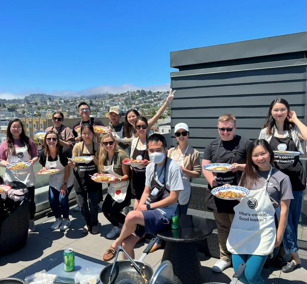 A group on a rooftop after a Thai cooking class with BiteUnite, a delicious team building activity in San Francisco’s Mission District.