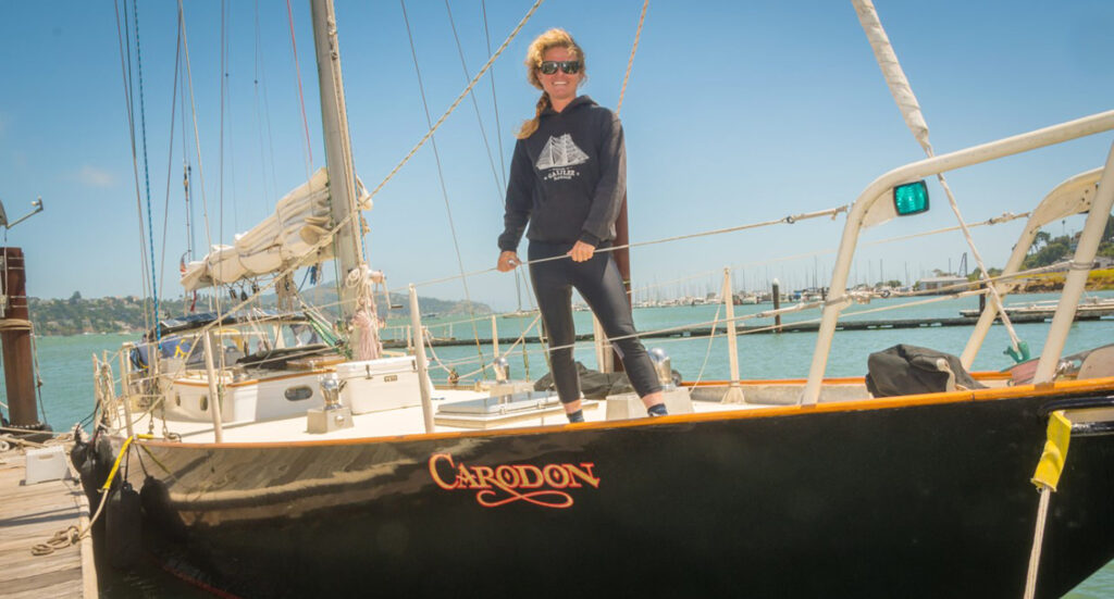 Captain Heather steering her boat during a sailing tour of the bay, a nautical team building activity.