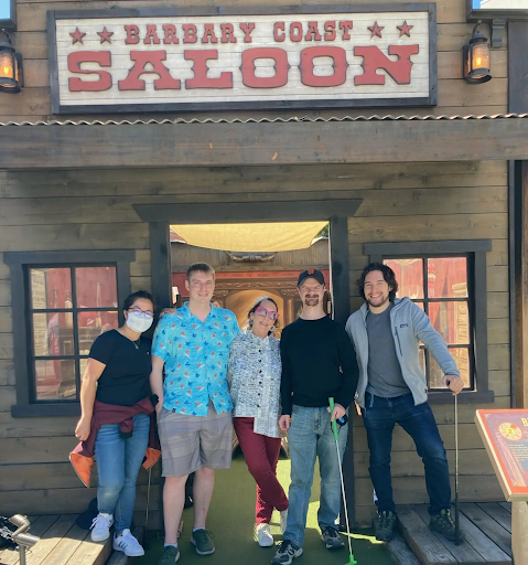 A group posing with mini-golf clubs at Stagecoach Greens, a fun and interactive team building activity in San Francisco.