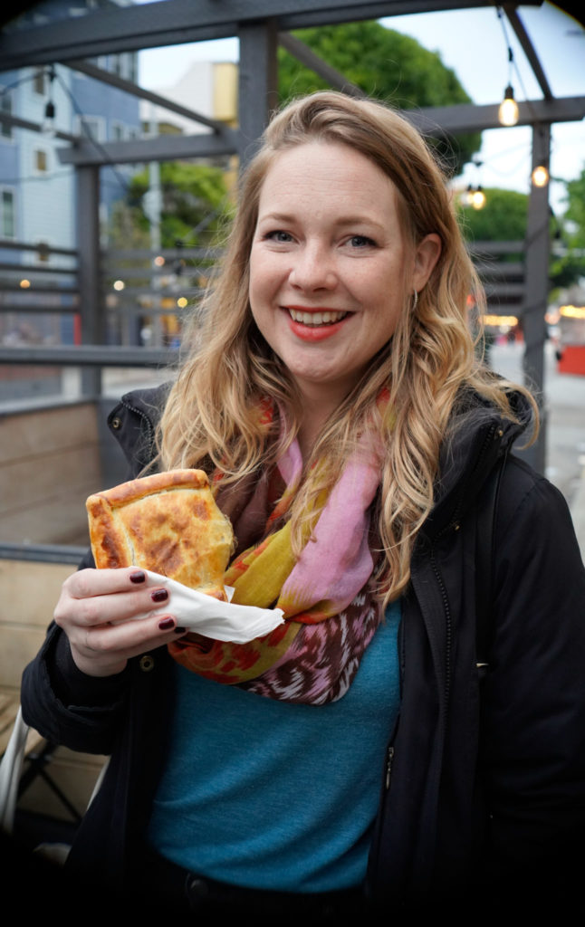 Lady tasting a pastry on a food tour in San Francisco. 