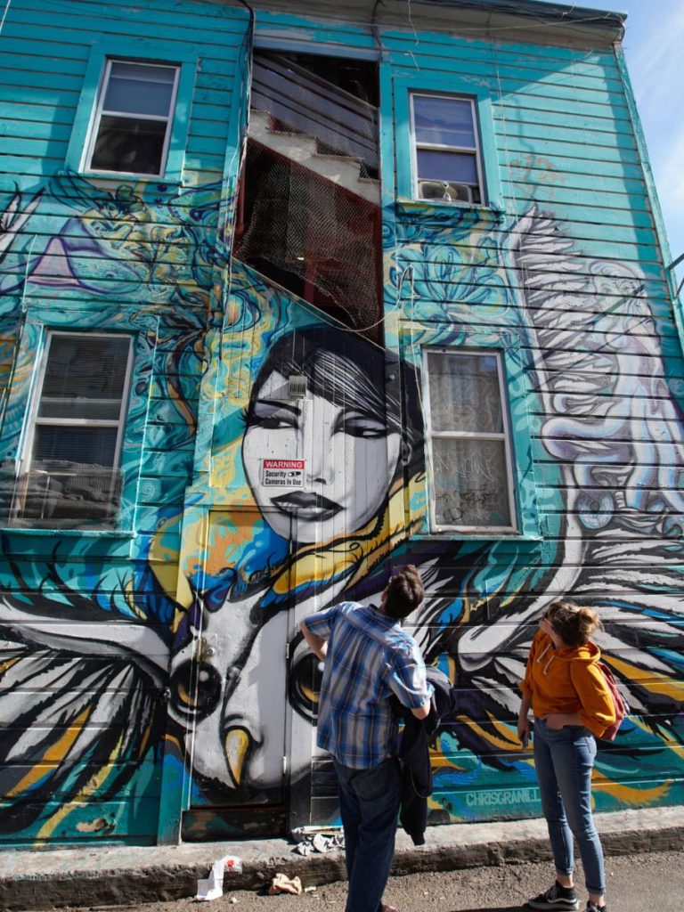 Two people discovering a mural on a client appreation event with Stretchy Pants Food Tours in San Francisco. 