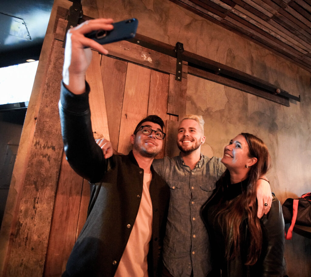 Three people taking selfies on a food tour in San Francisco. 