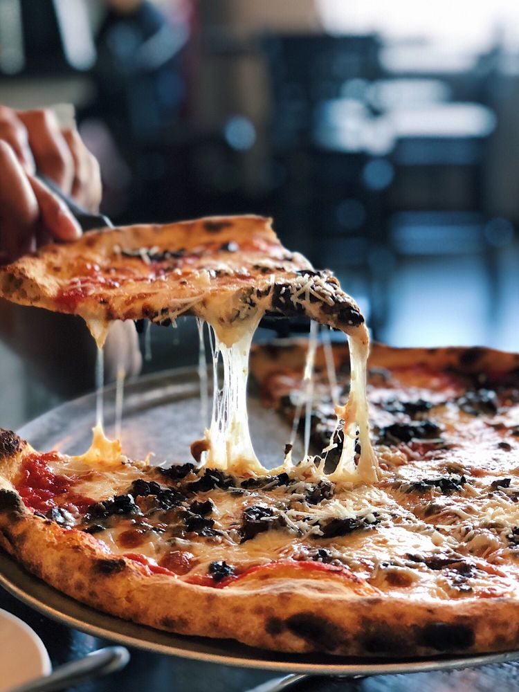 Close-up of a slice of pizza with a San Francisco sourdough crust being served at Long Bridge Pizza, showcasing their dedication to flavorful, artisanal dough.