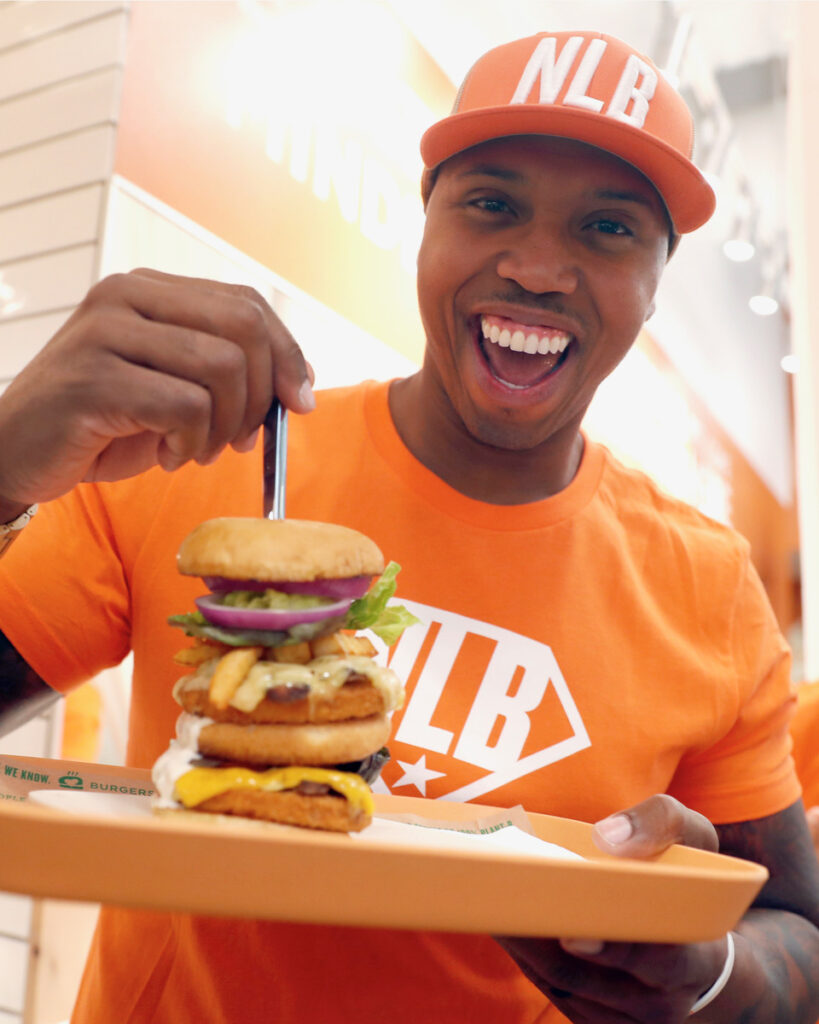 A person holding a Next Level Burger at Next Level Burger, one of the popular vegan restaurants in San Francisco located inside Whole Foods.