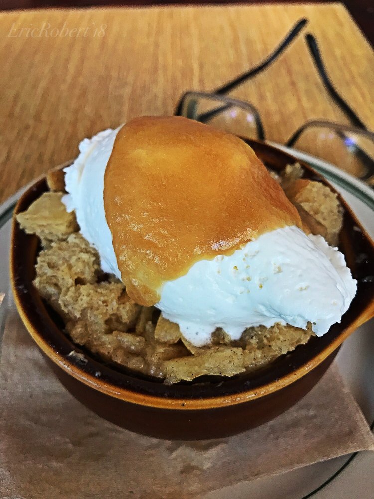 Close-up of sourdough bread pudding topped with ice cream at Woodhouse Fish Co., offering a unique twist on a classic dessert.